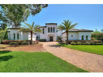 Two story home with white facade and palm trees at 12245 Park Ave, Windermere, FL 34786