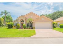 Tan house with a two-car garage and manicured lawn at 415 Seabrook Rd, Ormond Beach, FL 32174