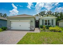 Single-story home with a two-car garage and landscaped lawn at 1743 Red Rock Rd, New Smyrna Beach, FL 32168