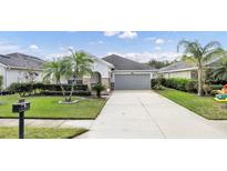 One-story home with gray garage door, landscaped yard, and palm trees at 105 Grande Berwick Ct, Daytona Beach, FL 32124