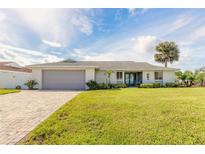 One-story home with gray garage door and landscaped lawn at 31 Sea Harbor E Dr, Ormond Beach, FL 32176