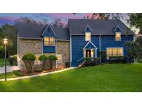 Charming two-story home with blue siding, stone accents, and well-manicured lawn at 9 Iroquois Trl, Ormond Beach, FL 32174