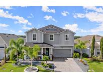 Two-story home with gray siding, landscaping, and paver driveway at 137 Azure Mist Way, Daytona Beach, FL 32124