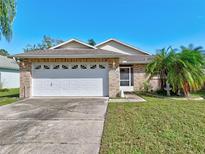 Brick home with a two-car garage and well-manicured lawn at 3804 Grove View Ln, Port Orange, FL 32129