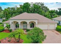 One-story house with two-car garage and lush landscaping at 21 Old Canyon Ln, Ormond Beach, FL 32174