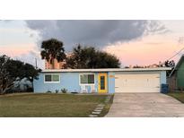 Light blue house with a two-car garage and lawn at 3257 S Peninsula Dr, Daytona Beach, FL 32118