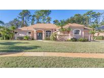 Single-story home with stucco exterior, tile roof, and lush landscaping at 3404 Rexford Cir, Ormond Beach, FL 32174