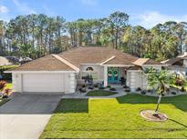 Single-story home with a two-car garage and landscaped lawn at 1732 Creekwater Blvd, Port Orange, FL 32128