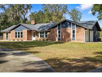 Brick and blue-sided home with a large yard and long driveway at 2181 Glenwood Hammock Rd, Deland, FL 32720