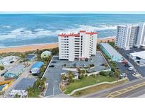 Aerial view of a beachfront condominium building with parking and nearby amenities at 1183 Ocean Shore Blvd # 1040, Ormond Beach, FL 32176