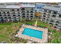 Aerial view of condo building, pool, and surrounding landscape at 2700 Ocean Shore Blvd # 508, Ormond Beach, FL 32176