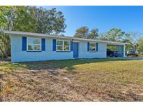 Light blue house with carport, and a well-maintained lawn at 1448 Richmond Ave, Daytona Beach, FL 32117