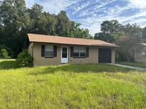 1-story house with brown roof and attached garage at 1215 E Hazzard Ave, Eustis, FL 32726