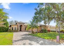 House exterior features a tile driveway, landscaping and a two-car garage at 5418 Meadow Hill Loop, Lady Lake, FL 32159