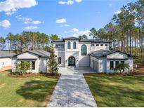Two-story house with a stone driveway and lush landscaping at 16340 Pendio Dr, Bella Collina, FL 34756