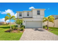 Two-story house with a gray garage door and landscaping at 2226 Lelani Cir, Davenport, FL 33897
