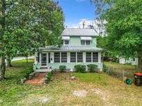 Charming two-story house with a light green exterior and a well-maintained yard at 5905 Se Earp Rd, Belleview, FL 34420