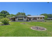 Ranch-style home with carport and manicured lawn at 9930 County Road 114B, Wildwood, FL 34785