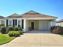 Single-story home with a covered carport and landscaping at 1350 Denaud Pl, The Villages, FL 32163