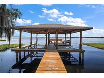 Lakefront property with a boathouse and dock at 1261 W Lakeshore Dr, Clermont, FL 34711