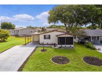 Single-story home with a carport and landscaped yard at 615 Rainbow Blvd, The Villages, FL 32159