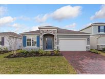 Charming single-story home with a brick driveway, blue shutters, and a landscaped front yard at 5832 Springer St, Saint Cloud, FL 34771