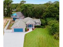 Aerial view of a two-story house with a detached garage at 12270 Virginia Dr, Leesburg, FL 34788