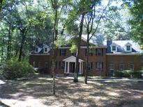 Brick house with large trees and a green lawn at 415 Se 123Rd Street Rd, Ocala, FL 34480