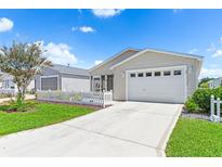 Tan house with white picket fence, attached garage, and driveway at 2809 Burgos Dr, The Villages, FL 32162