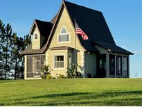 A charming two-story home with a unique architectural design and manicured lawn at 13910 Max Hooks Rd, Clermont, FL 34711