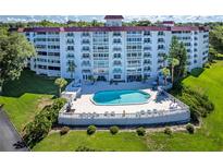 Aerial view of a condo building with a pool and lush landscaping at 601 N Mcdonald St # 608, Mount Dora, FL 32757
