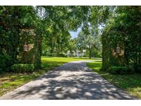 Grand entrance to estate with lush landscaping at 6779 Clayton St, Mount Dora, FL 32757