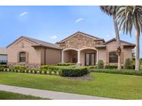 Exterior of a single-story house with stone accents at 25499 Hawks Run Ln, Sorrento, FL 32776