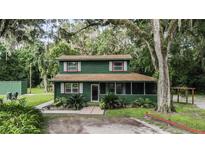 Charming two-story green house surrounded by trees at 1773 C 44A, Wildwood, FL 34785