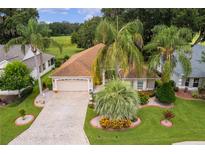 Single-story house with paver driveway, landscaping, and palm trees at 7151 Se 173Rd Arlington Loop, The Villages, FL 32162