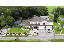 Two story house with pool, lush landscaping, and large driveway at 1304 Ocoee Apopka Rd, Ocoee, FL 34761