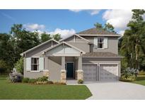 Two story home with light gray siding, stone accents and teal doors at 2396 Juniper Berry Dr, Minneola, FL 34715