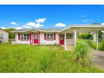 One-story house with red door and carport at 1620 Morin St, Eustis, FL 32726
