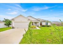 One-story home with a two-car garage and a well-maintained lawn at 394 W 9Th St, Frostproof, FL 33843