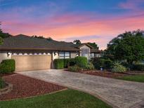 House exterior at dusk with landscaped yard at 21821 Prince William Ct, Leesburg, FL 34748