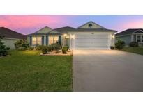 Single-story home with a two-car garage and well-maintained lawn at 11394 Zimmerman Path, Oxford, FL 34484