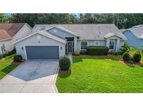 Single-story home with a gray garage door and a compass-designed driveway at 3912 Plantation Blvd, Leesburg, FL 34748