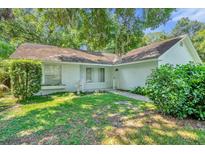 Single-story house with white exterior, green lawn, and mature trees at 1500 Cobble Ln, Mount Dora, FL 32757