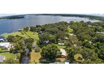 Aerial view showcasing a home on a waterfront lot with lush landscaping at 10367 Se Sunset Harbor Rd, Summerfield, FL 34491
