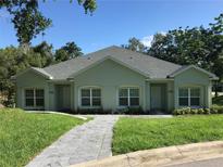 Two-unit building with green exterior and paved walkway at 124 Orange Ave, Clermont, FL 34711