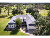 Single-story home with a large yard and golf course view at 557 Dowling Cir, Lady Lake, FL 32159