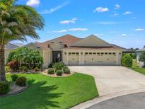Two-story house with three-car garage and manicured lawn at 3162 Webster Way, The Villages, FL 32163