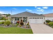 Single-story home with a white garage door and landscaped yard at 5452 Zajac Ave, The Villages, FL 32163