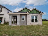 Newly constructed single-story home with block exterior and covered porch at 10593 Grand Oaks Blvd, Oxford, FL 34484