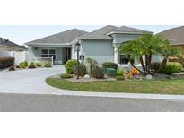 Well-manicured front yard with palm trees and circular driveway at 2968 Wotring Way, The Villages, FL 32163